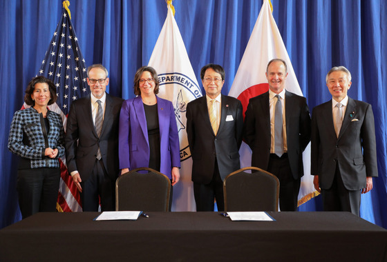UW Provost Tricia Serio alongside industry and academic partners at the US Dept of Commerce in front of the signed partnership agreement